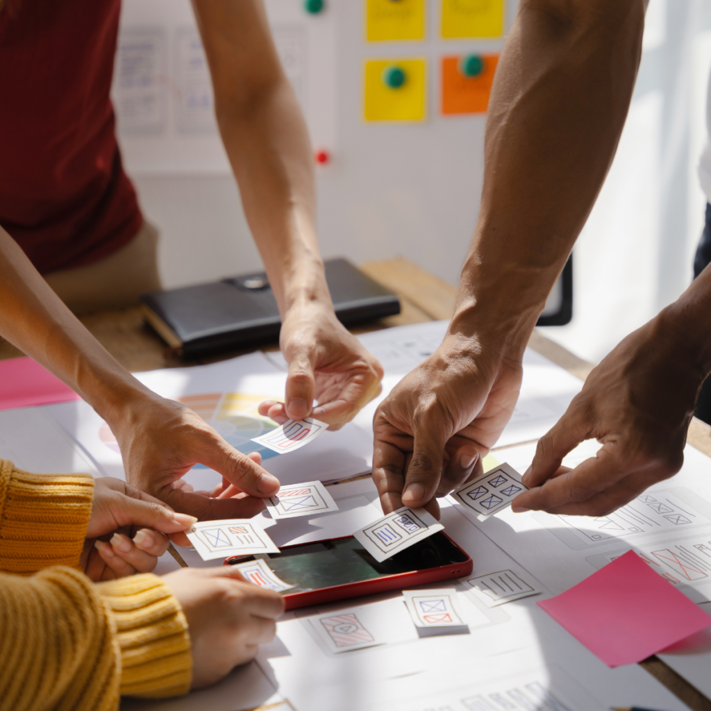 Team reviewing app designs and prototypes for client delivery